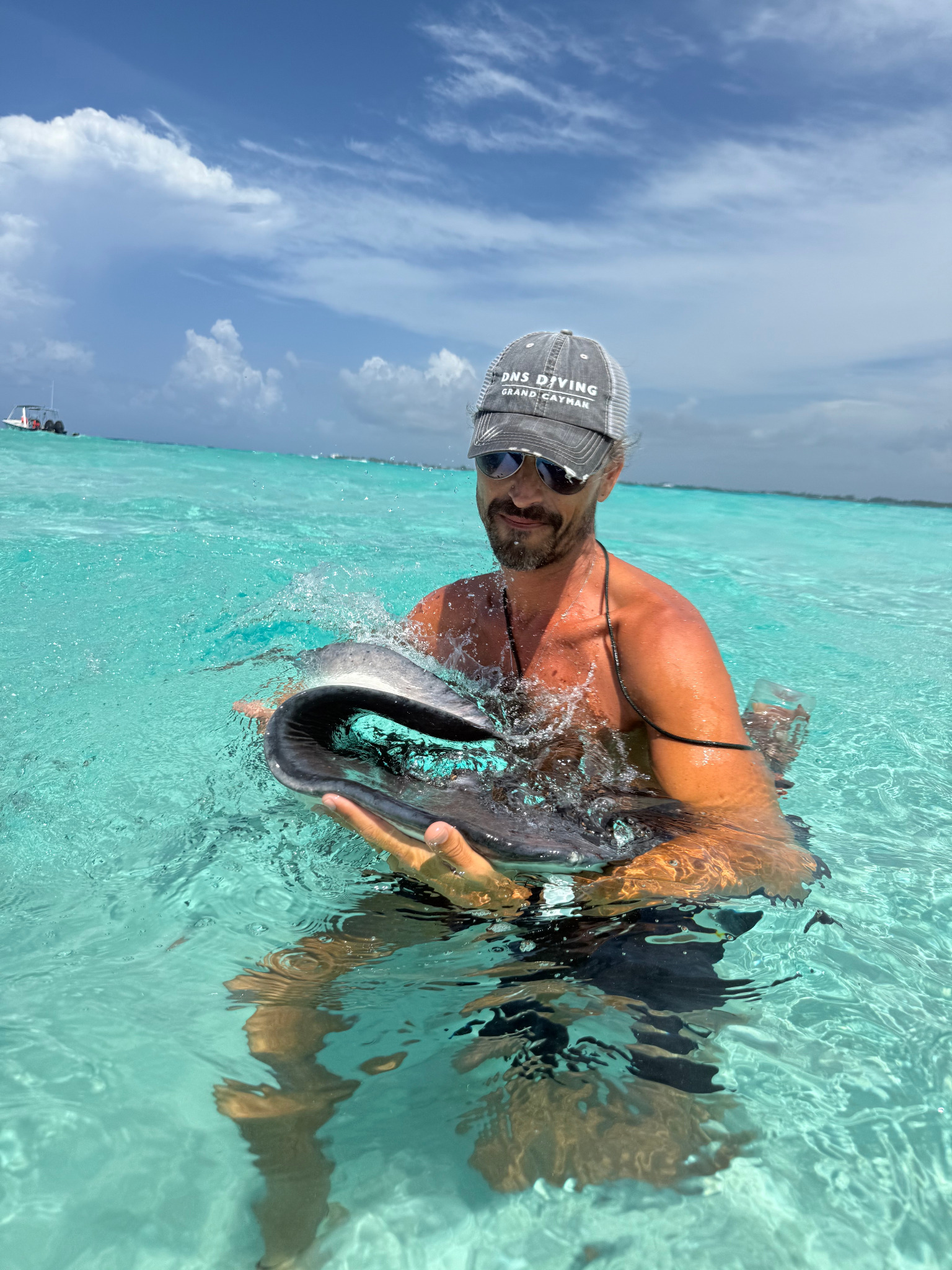 DNS Diving crew assisting guests during a Stingray City experience in Grand Cayman.