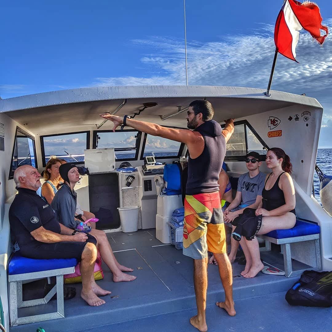 DNS Diving crew member briefing a small group of guests aboard the dive boat