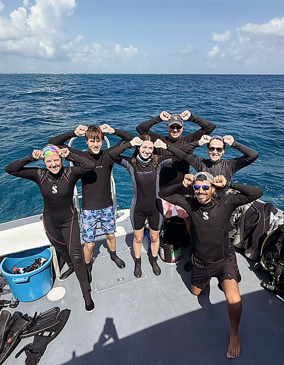 Happy group of DNS Diving guests and crew aboard the boat in Grand Cayman